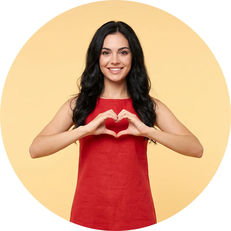 Brand experience – experiențe care creează conexiuni reale cu brandul Femeie zâmbitoare formând o inimă cu mâinile, ilustrând relația emoțională și conexiunea din brand experience